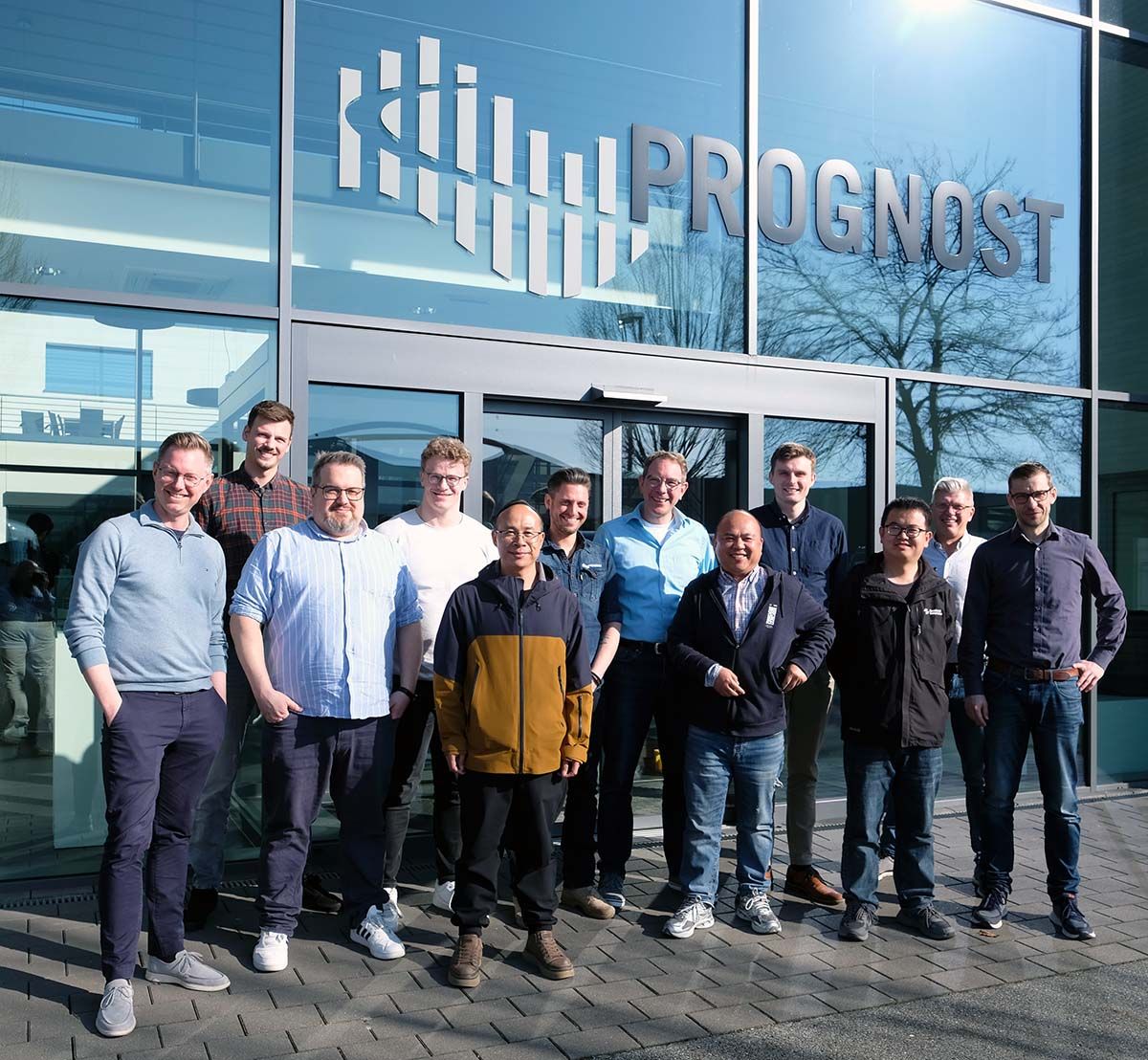 Customer support trainers standing together with visitors in fron og the PROGNOST headquarters.